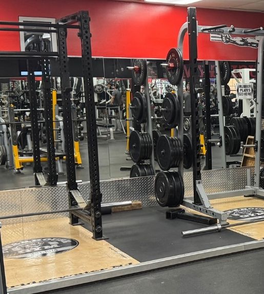 Strength training area at Powerhouse Gym Bridgewater NJ with squat rack and weight plates